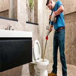 unclogging-toilet-using-drain-snake
